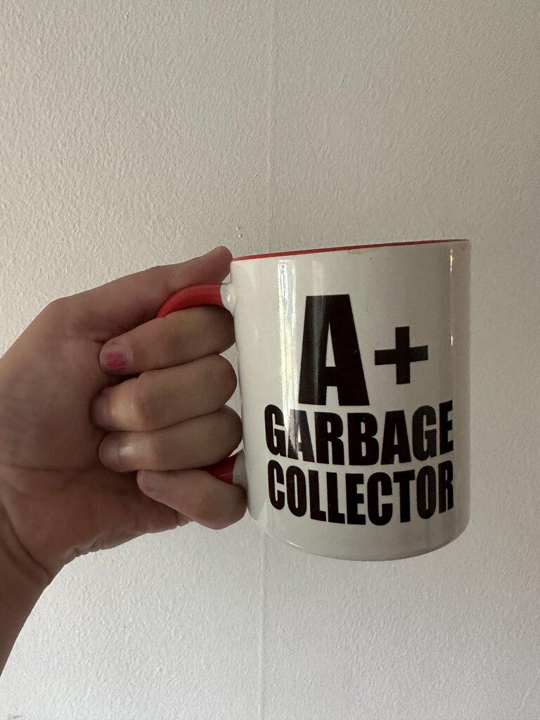 Coffee mug that says 'A+ Garbage Collector'